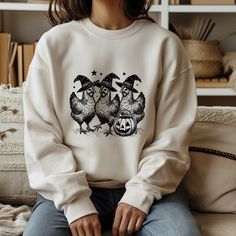 Add some humor to your spooky season with our Chicken Witches Funny Halloween sweatshirt! Featuring a vintage-inspired design of quirky chicken witches, this sweatshirt is perfect for women who love a playful twist on Halloween. Cozy, fun, and sure to bring smiles, it's a great choice for Halloween parties or fall outings. Stand out with this unique and funny Halloween sweatshirt that's perfect for spreading spooky cheer!" The perfect gift! Our sweatshirts are 100% made in the USA, crafted from a high-quality unisex fabric that is incredibly soft. It will be one of the coziest, best-fitting, and most comfortable sweatshirts you've ever owned. Before ordering, please check the dimensions on the sweatshirt size chart to ensure the perfect fit. The measurements listed are accurate. We take pr Halloween Cozy, Fall Outings, Witch Sweater, Vintage Chicken, Funny Women, Sweatshirt Vintage, Women Halloween, Halloween Parties, Branded Sweatshirts