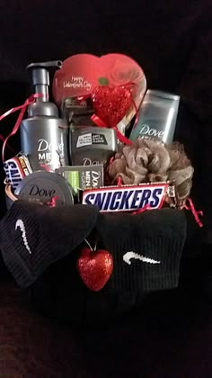 a basket filled with lots of different items on top of a black table next to a red heart