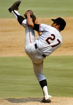 a baseball player pitching a ball on top of a field