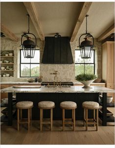 a large kitchen with black cabinets and white counter tops, two pendant lights over the island