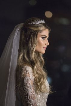 a woman in a wedding dress with a tiara on her head and veil over her head