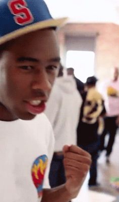 a young man wearing a baseball cap and white shirt