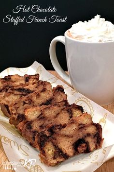 there is a piece of cake on the plate next to a cup of hot chocolate