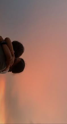 two people are looking up at the sky with clouds in the background