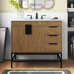 a bathroom with a sink, mirror and rug on the floor in front of it