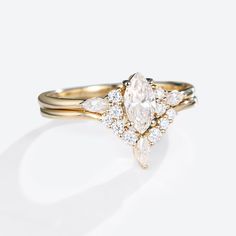 a gold ring with a pear shaped diamond surrounded by small white and yellow diamonds on the band