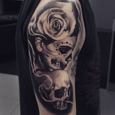 a man's arm with a skull and rose tattoo on it