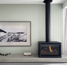 a fireplace in a living room with a painting on the wall and a fire place next to it