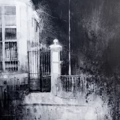 a black and white photo of a street light in front of a building with an iron fence