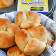 some bread rolls are in a basket on a table