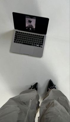 a person laying on the ground with their feet up in front of a laptop