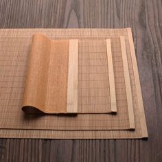 four pieces of wood laid out on top of a wooden flooring mat, with one piece cut in half