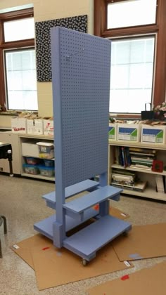 a large blue object sitting on top of a table in a room filled with books