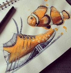 a drawing of an orange fish on top of a piece of paper next to a pen