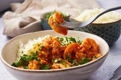 a bowl filled with rice and shrimp next to a fork full of food on top of it