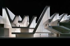 an architectural model of a building with stairs and people walking around it at night time