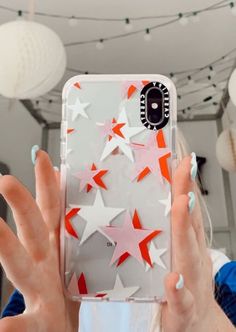 a woman holding up her phone case with stars on it