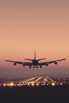 an airplane is taking off from the runway at sunset or dawn with its landing gear down