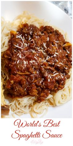 spaghetti with meat sauce and parmesan cheese on top is served in a white bowl