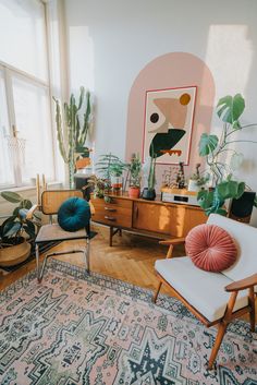 a living room filled with lots of plants and furniture