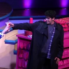 a man standing next to a woman in front of a pile of pink plastic cups