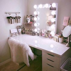 a white vanity with lights on it and a fur coat hanging from the top shelf