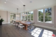 a large dining room with hardwood floors and windows