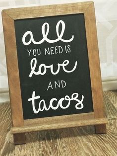 a chalkboard sign that says all you need is love and tacos on it