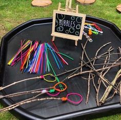 a black tray filled with lots of different types of colored sticks and twigs