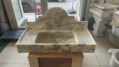 a marble sink sitting on top of a wooden stand