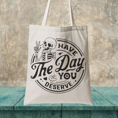 a tote bag that says have the day you deserves