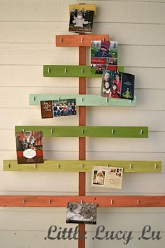 a christmas tree made out of wooden planks with pictures hanging on the top and bottom