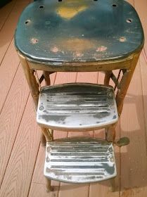 two metal stools sitting on top of a wooden floor