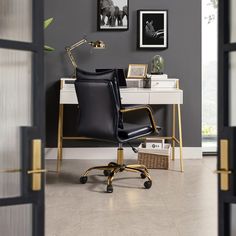 an office chair sitting in front of a desk with pictures on the wall behind it