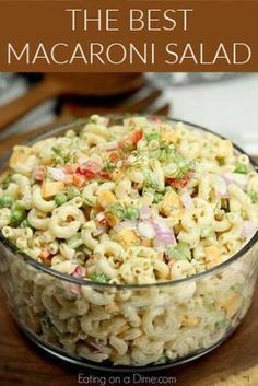 macaroni salad in a glass bowl on top of a wooden cutting board with text overlay