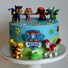 a birthday cake with paw patrol figurines on top