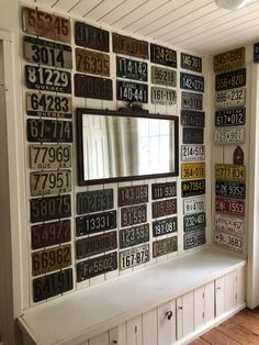 a room with lots of old license plates on the wall and a mirror above it