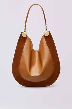 This modern hobo bag is made in a soft leather and suede, and accented with sleek gold hardware. It has a leather strap and magnetic snap closure. Cute Handbags, Hobo Handbags, Leather Hobo, Beautiful Bags, High Heel Sandals, Hobo Bag, Leather Handle, Luxury Handbags, Tote Handbags