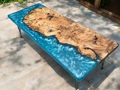 a table that is made out of wood and blue glass on the outside patio area