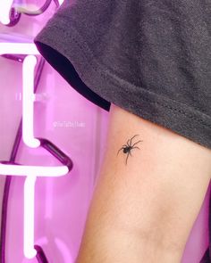 a small spider tattoo on the arm