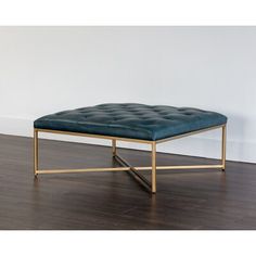 a square footstool with a gold frame and blue leather upholstered seat