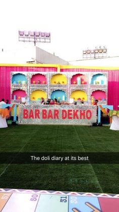 an advertisement for the bar dekho is displayed in front of a carnival tent