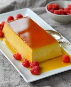 a piece of cake sitting on top of a white plate with raspberries next to it