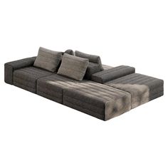 a large gray couch with pillows on it's back and side facing the camera