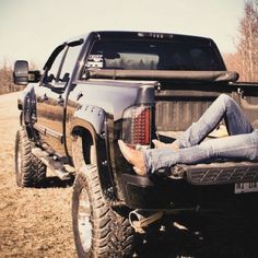 a man laying on the bed of a truck