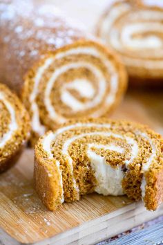 a cinnamon roll is cut in half on a cutting board