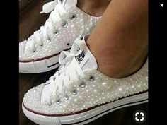 someone is wearing white shoes with pearls on them