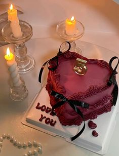 a heart shaped cake on a table with candles