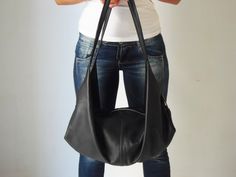 "A black leather shoulder bag with a unique design made from soft Italian pebbled leather named DeLuna. DeLuna is a large hobo bag designed for women who love to carry slouchy handbags. Handcrafted from soft cowhide leather and paired with nickel-tone hardware you will find inside one main compartment with a large zip pocket and 3 more slip pockets. This sling bag has a wide top opening and it is secured with a top zip. We use the best YKK zippers for our bags. Featured in this listing in soft b Casual Black Leather Hobo Bag, Black Soft Leather Crossbody Hobo Bag, Black Soft Leather Hobo Crossbody Bag, Black Soft Leather Hobo Bag For Shopping, Versatile Black Hobo Bag With Removable Pouch, Versatile Black Hobo Bag, Versatile Black Hobo Bag For Everyday, Black Soft Leather Hobo Shoulder Bag, Versatile Black Hobo Bucket Bag