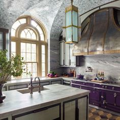 a kitchen with purple cabinets and an arched window in the ceiling is pictured here, along with a marble countertop